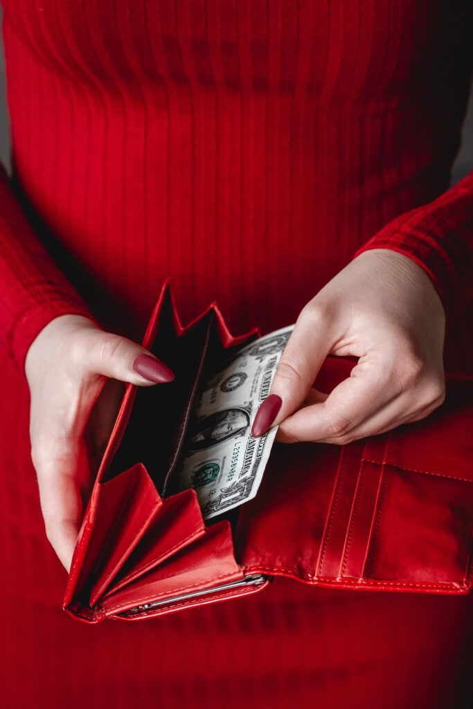 Red wallet in the hands of woman in a red dress with red manicur - Immo Safe