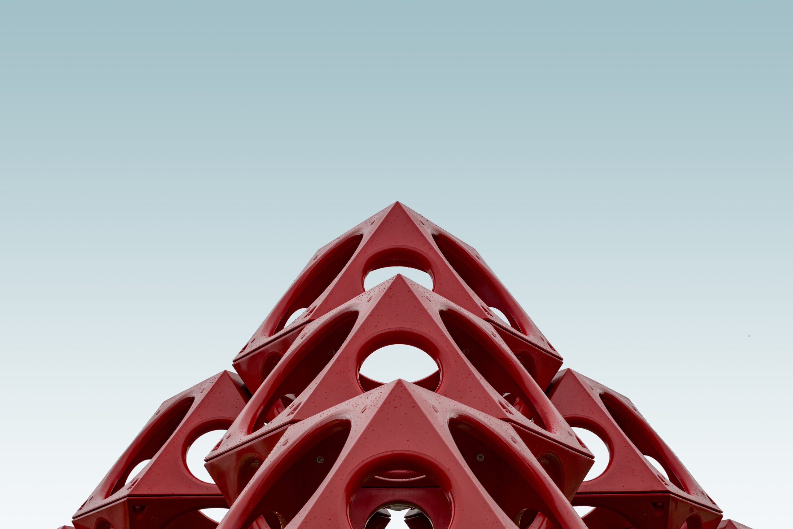 Low angle shot of a red geometrical structure under the blue sky - Immo Safe