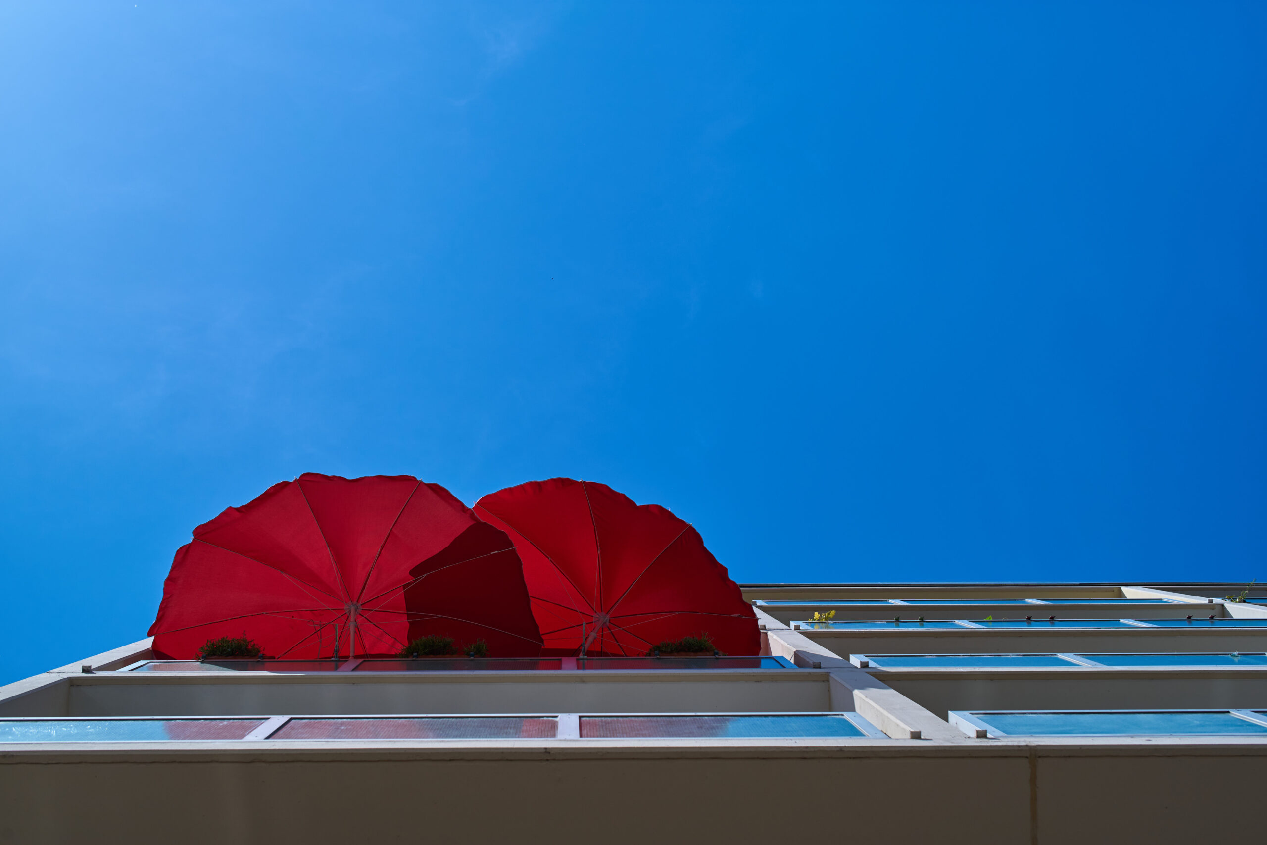 directly-shot-red-umbrella-against-blue-sky - Immo Safe